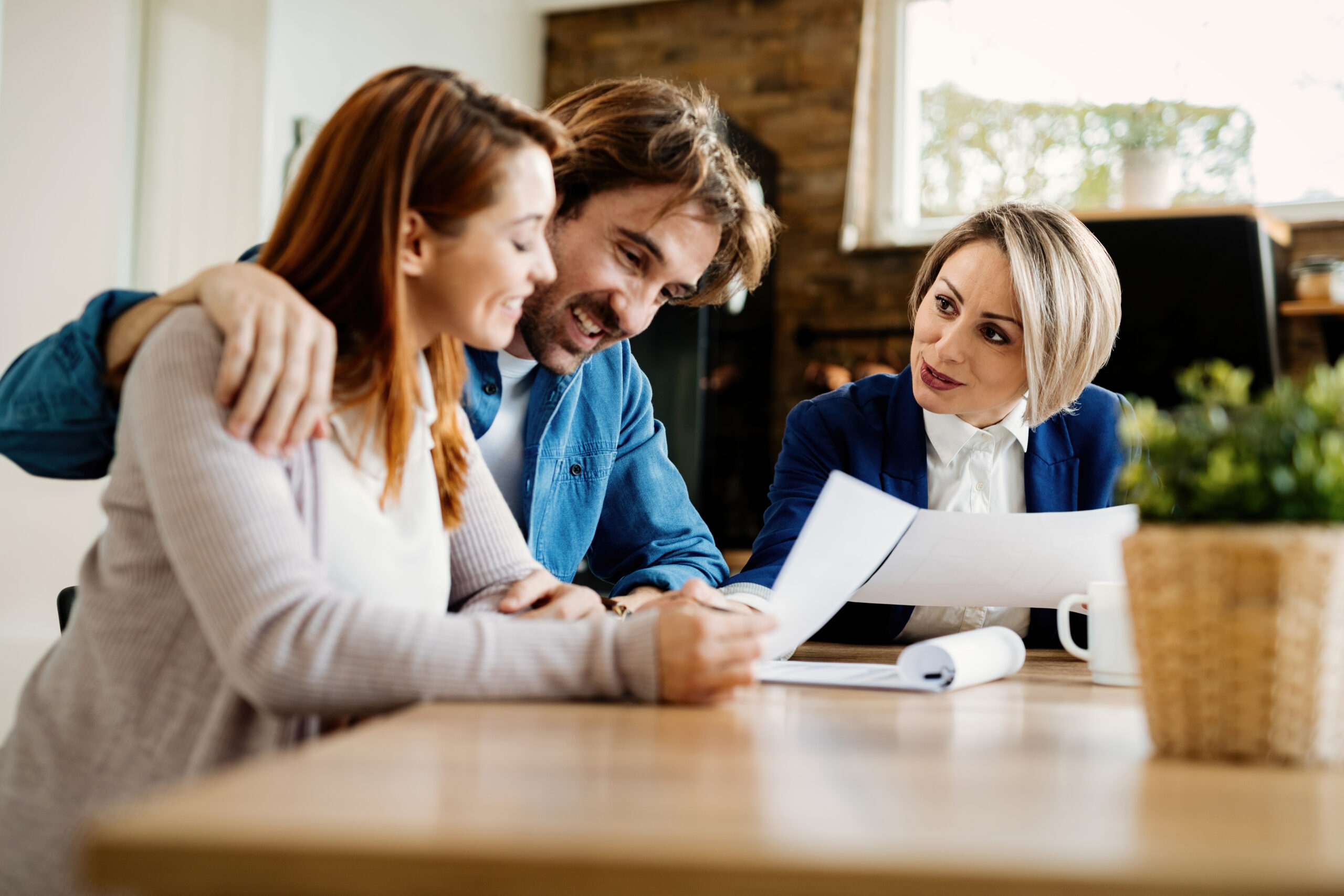 happy financial advisor having consultations with young couple their home scaled